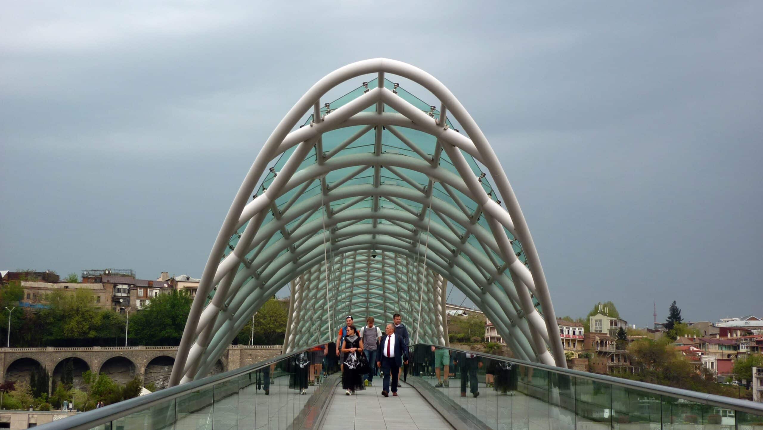 People walking through Tbilisi Bridge of Peace