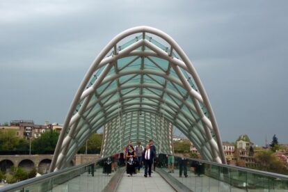 People walking through Tbilisi Bridge of Peace